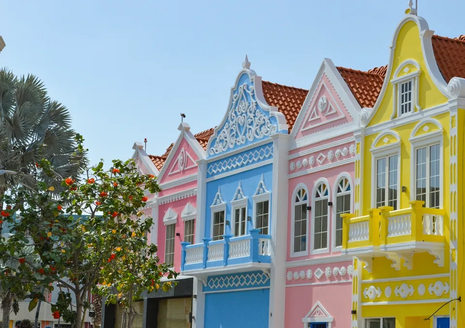 Pastel Dutch-Caribbean facades in San Nicolas under a clear Aruba sky.